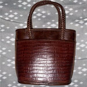 Brown leather purse with braided leather handles.